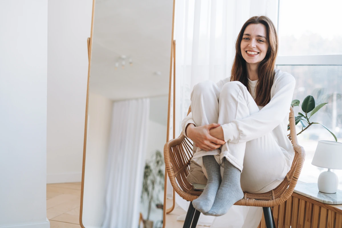 Une femme souriante assise seule dans une chaise