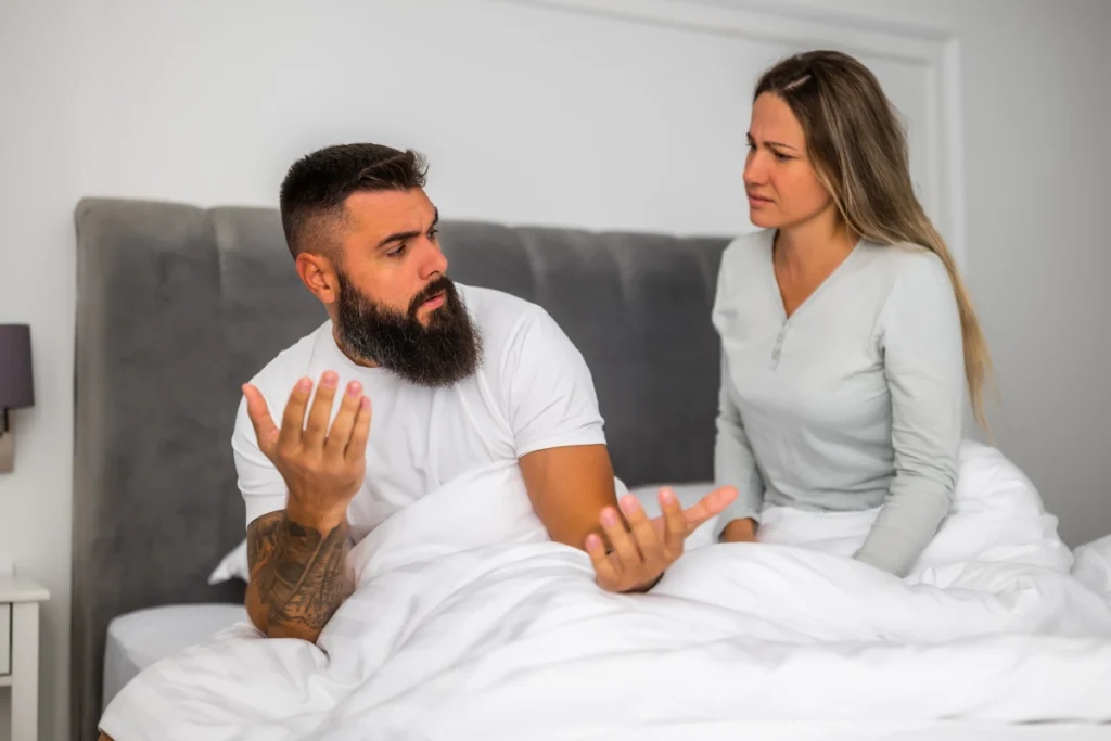 Un homme et une femme qui se dispute dans un lit