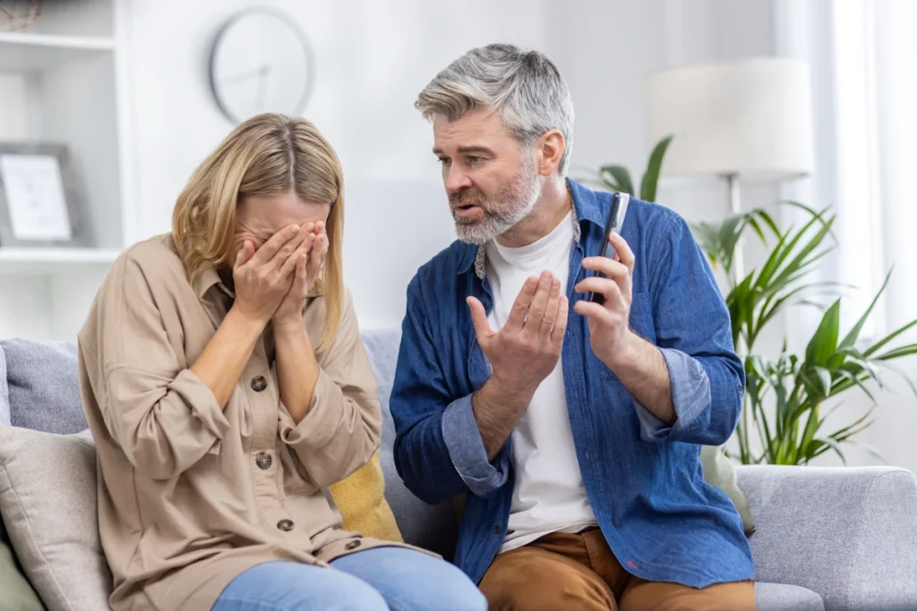 Un homme qui continue de parler à une femme qui pleure sur le canapé