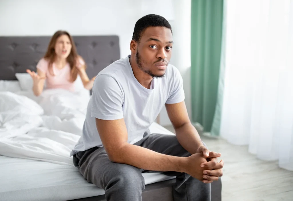 Un homme qui ignore sa femme qui parle dans le lit derrière lui