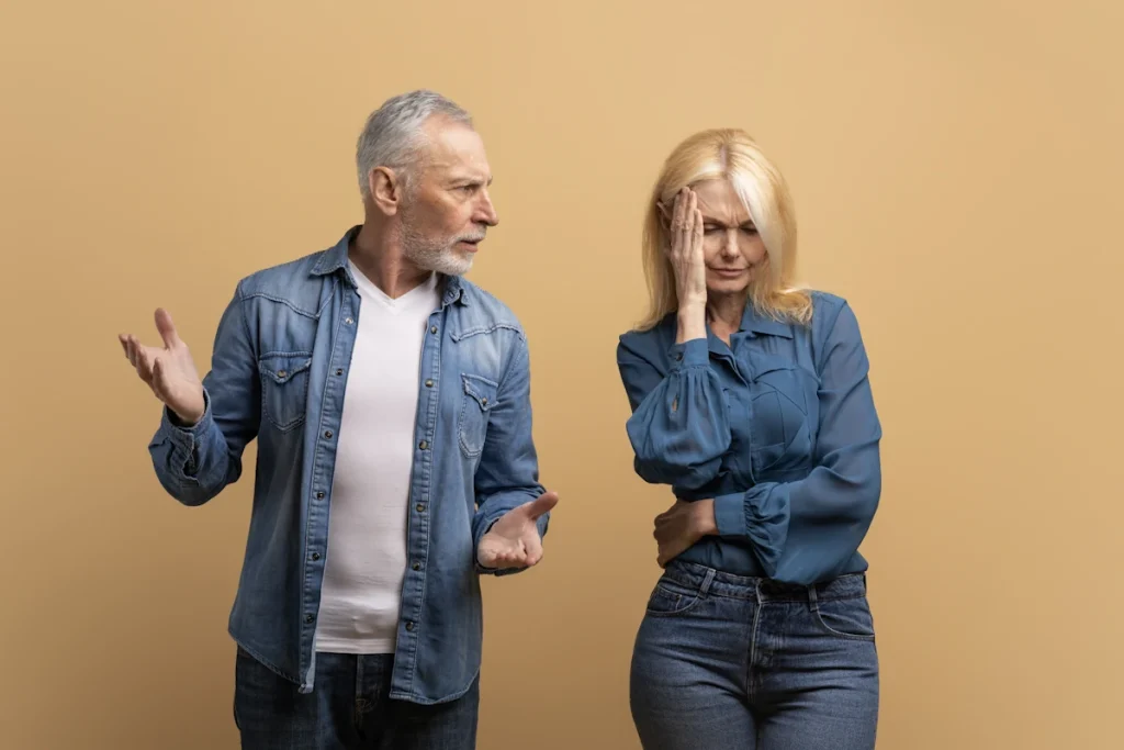 Un homme qui menace une femme ave sa main. elle se cache le visage en pleurant