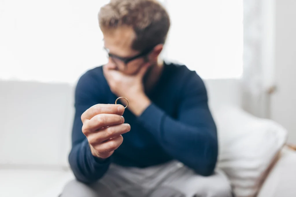 Un homme flouté qui tient sa bague en tournant la tête
