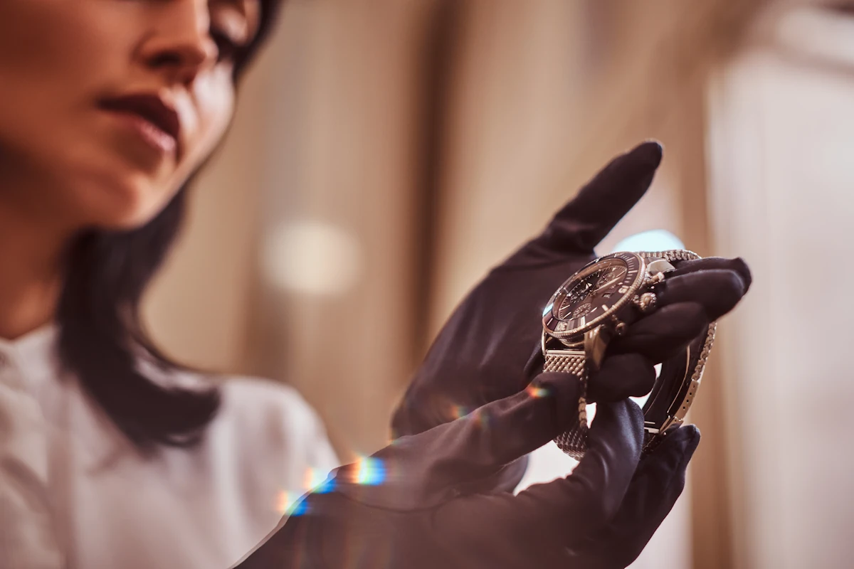 Une femme gantée qui tient une montre