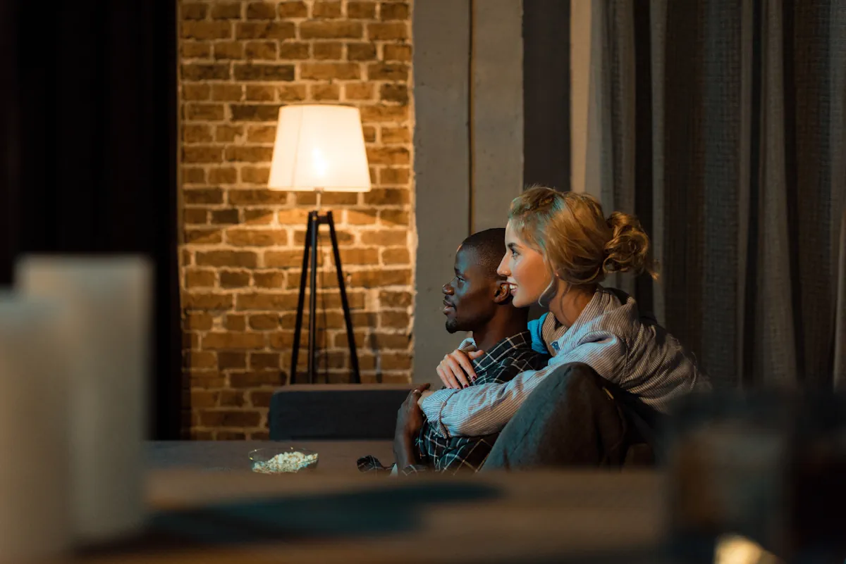 Un couple qui se fait un câlin sous la lumière chaude d'un lampadaire d'intérieur