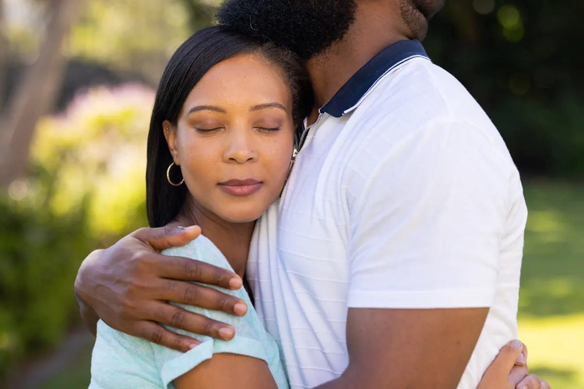 Un homme qui tient une femme dans ses bras. Elle ferme les yeux
