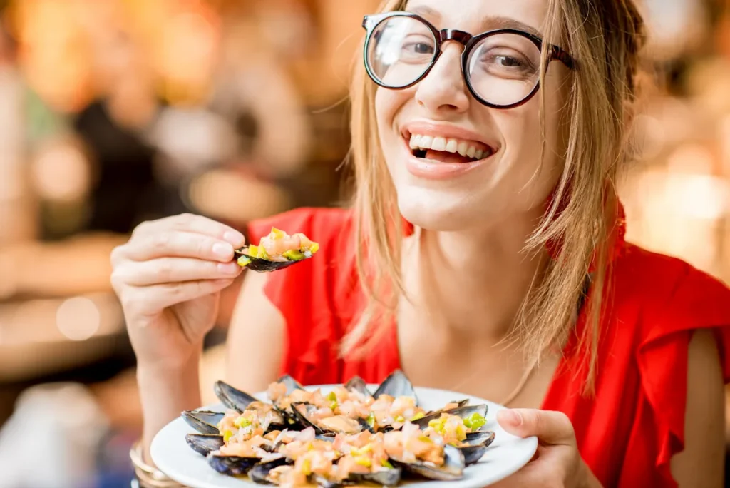 Une femme qui mange un plat d'huites