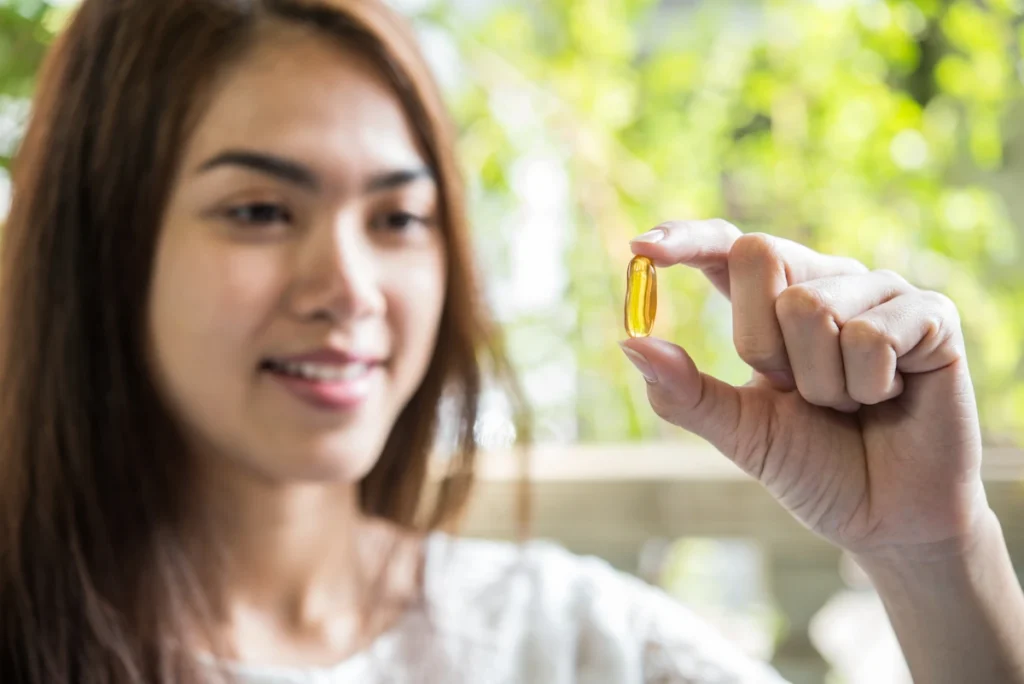 Une femme qui regarde une gélule jaune