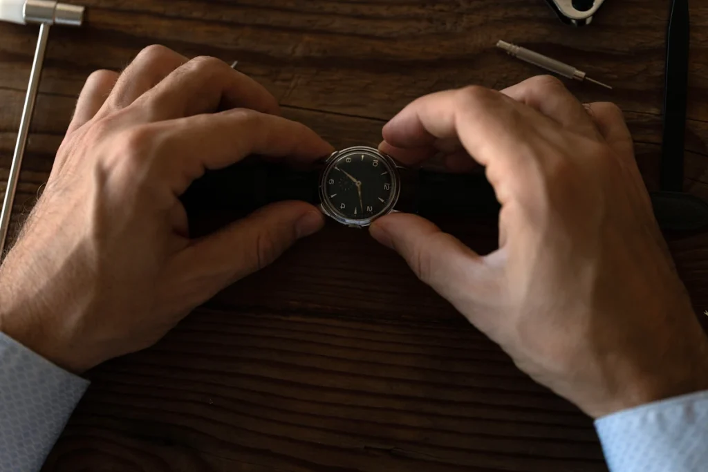 Un homme qui tient une montre sur une table