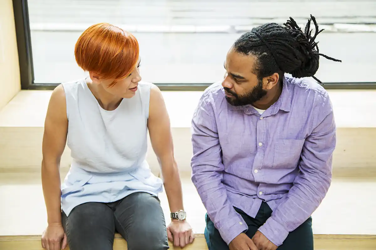Un homme et une femme qui discutent en étant assis