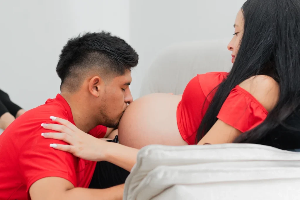 Un homme qui embrasse le ventre d'une femme enceinte