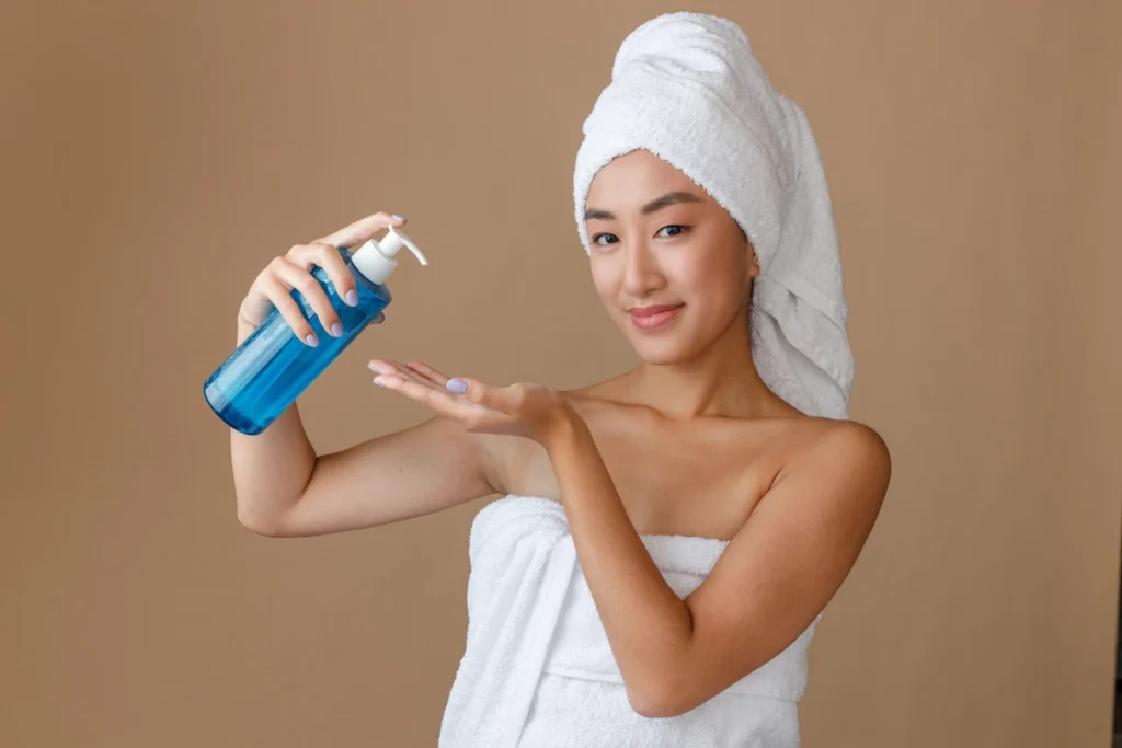 Une femme en serviette qui applique un produit