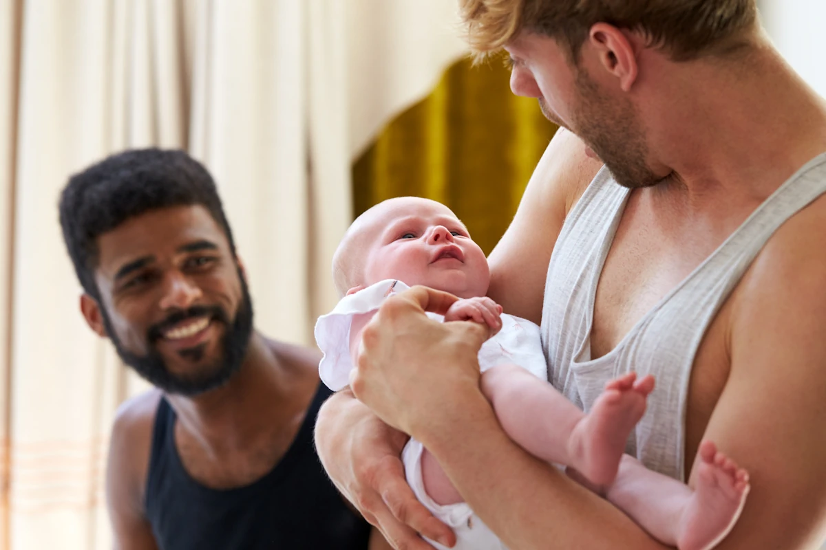 Un homme qui berce un bébé à côté d'un autre