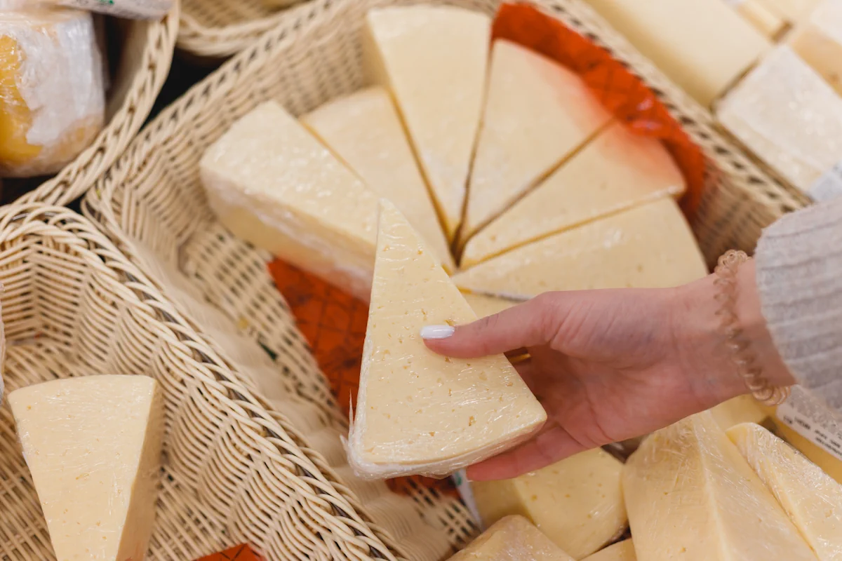 Une personne qui prend un morceau de fromage