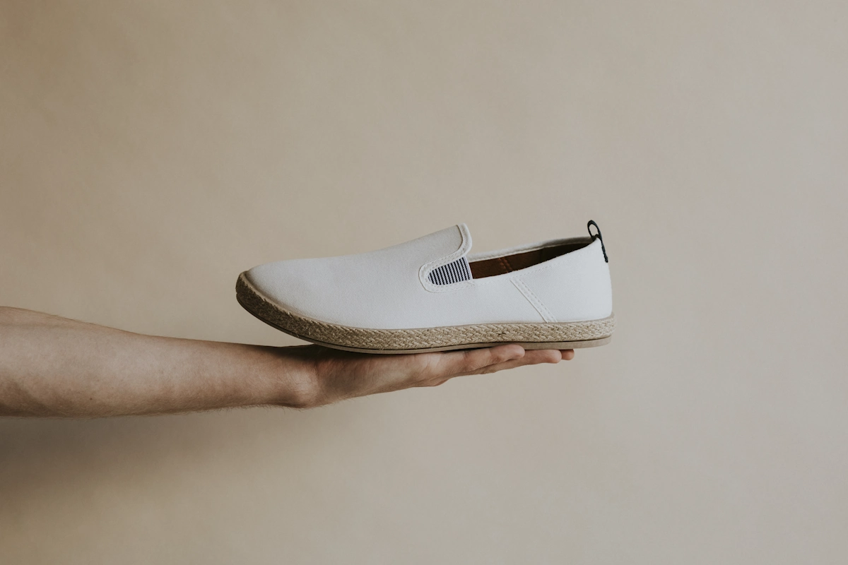 Un espadrille sur la main d'une personne