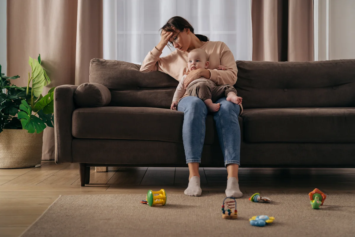 Une femme avec son enfant en burn out sur le canapé