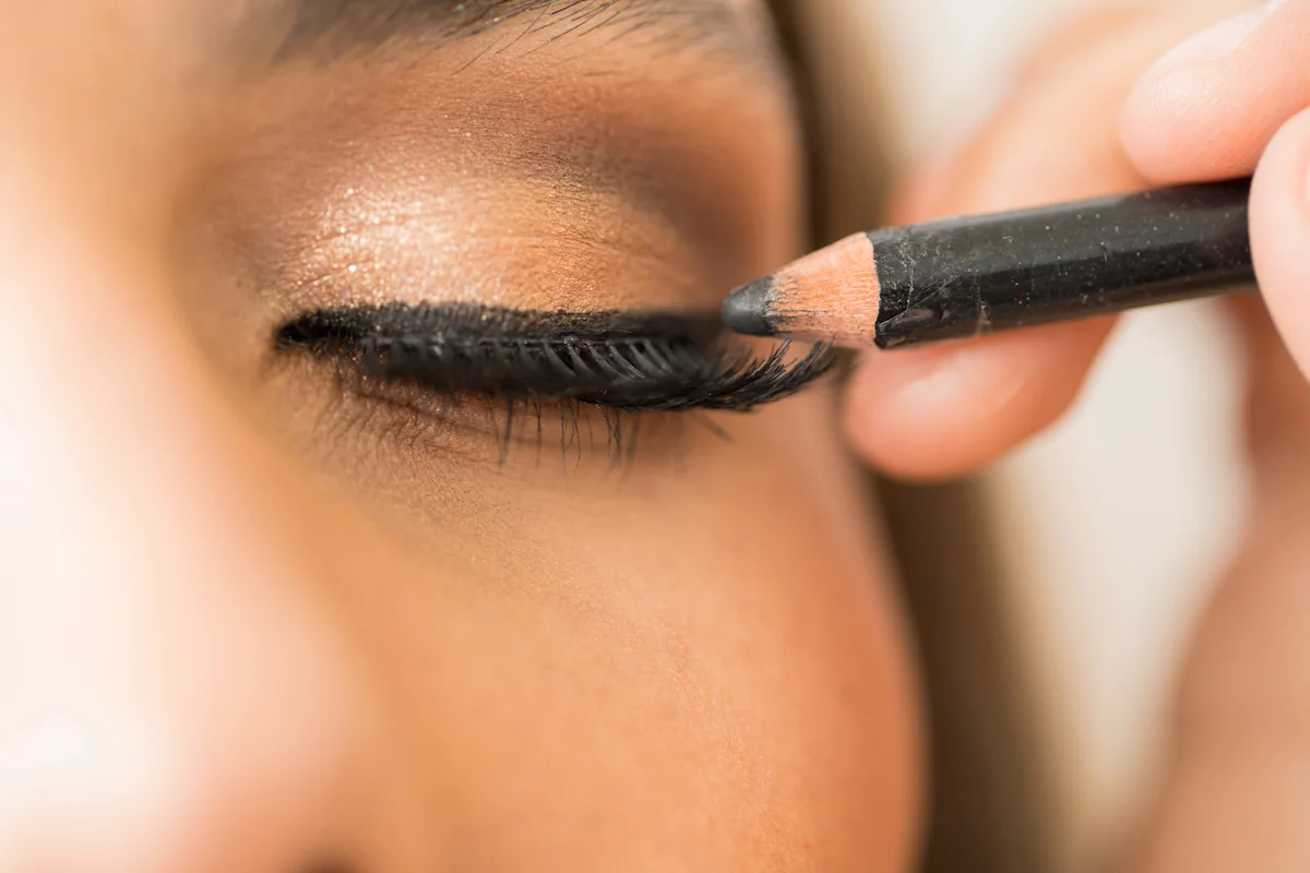 Une femme qui applique un crayon eye-liner waterproof