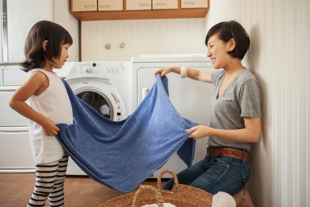 Une maman avec son enfant qui gère la lessive