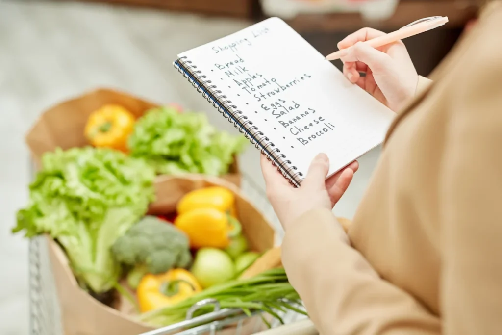 Une personne qui fait une liste de courses pour le batch cooking familial